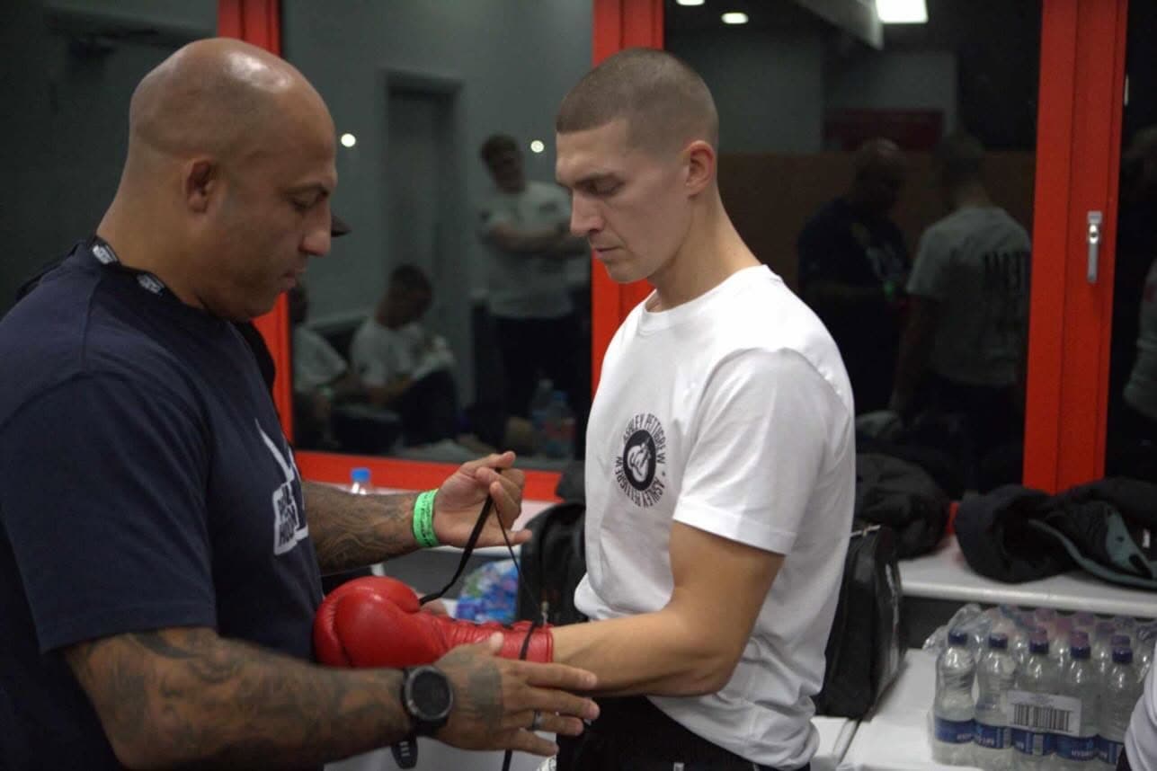 Coach wrapping a fighter's hands before training