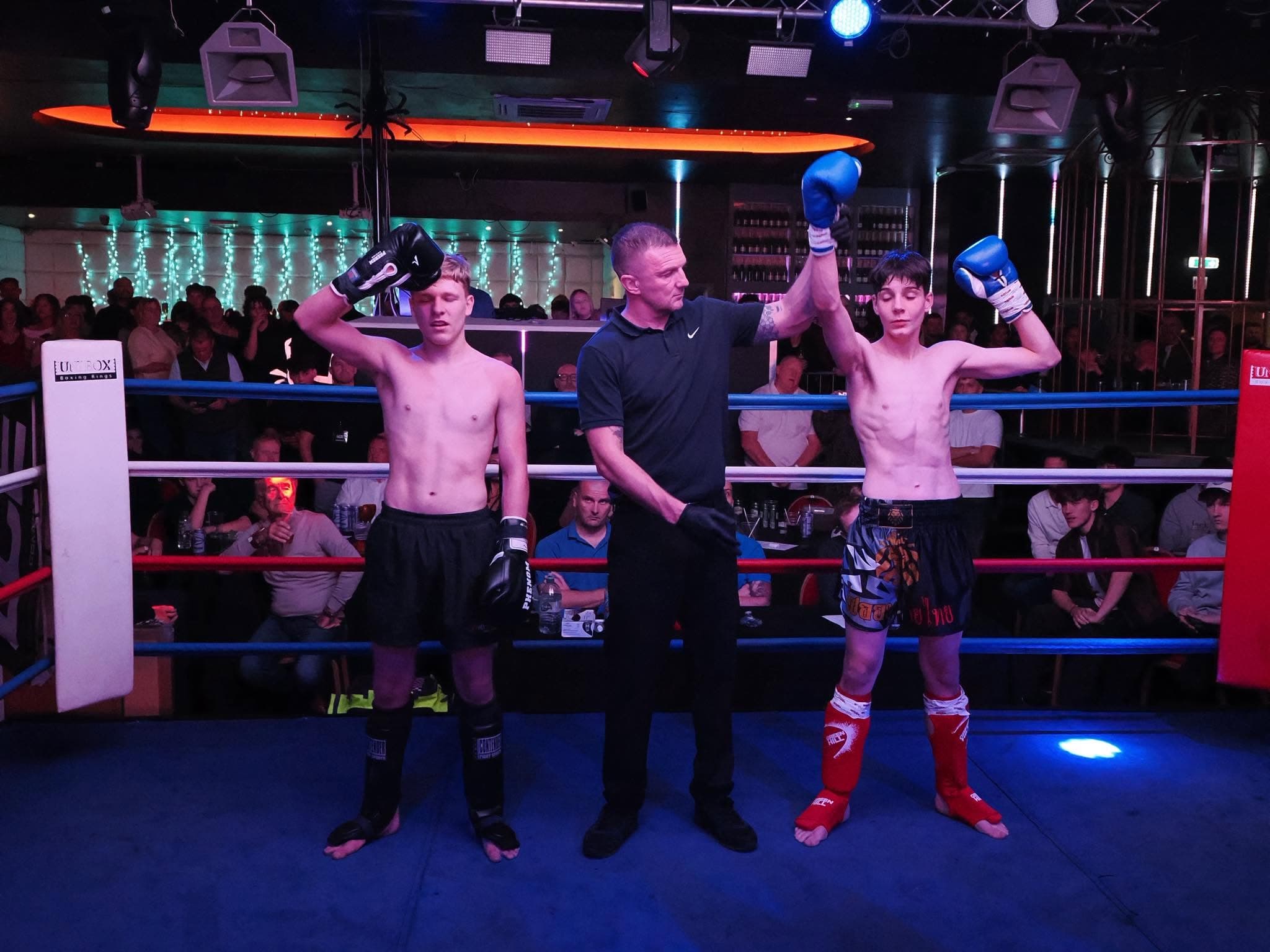 Referee raising the winner's hand after a bout