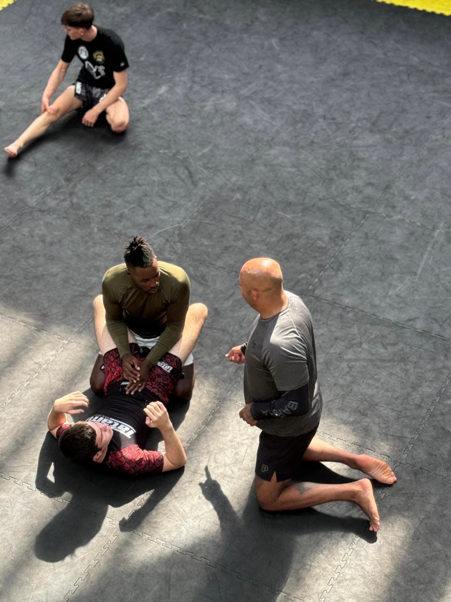 Coach talking with students on the gym mats